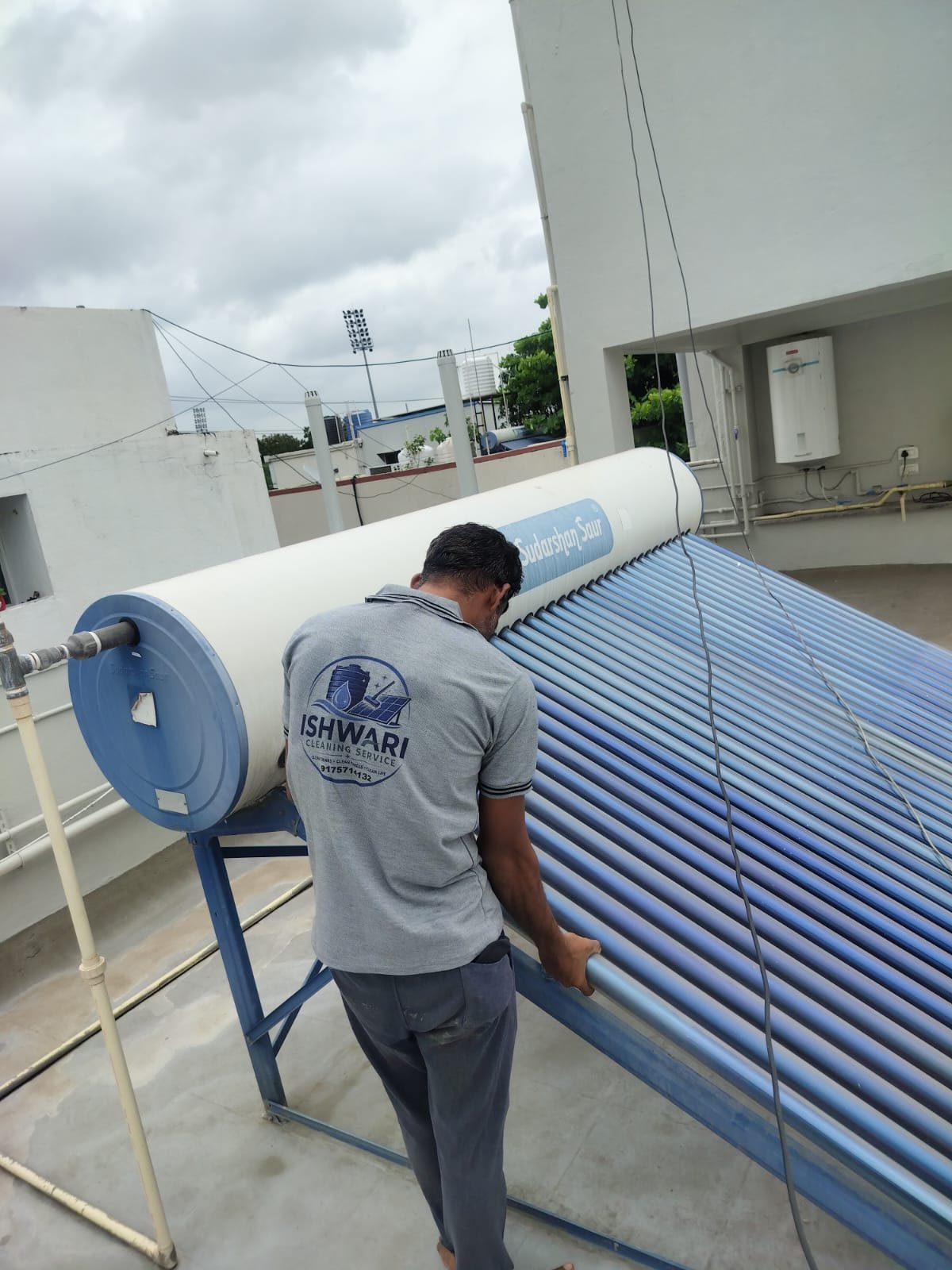 Technician cleaning the tubes of a rooftop solar water heater